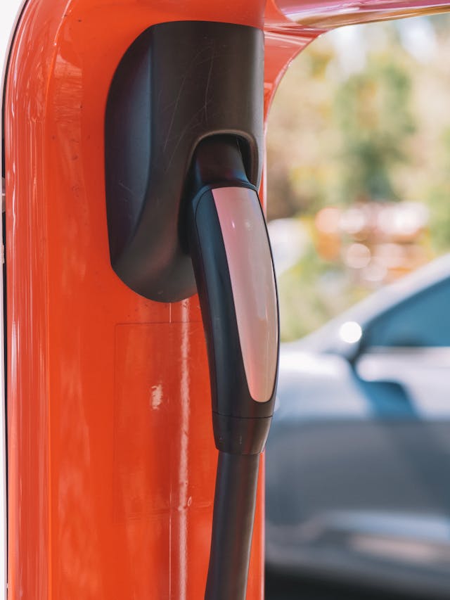 Electric vehicle charging station with charger plugged in